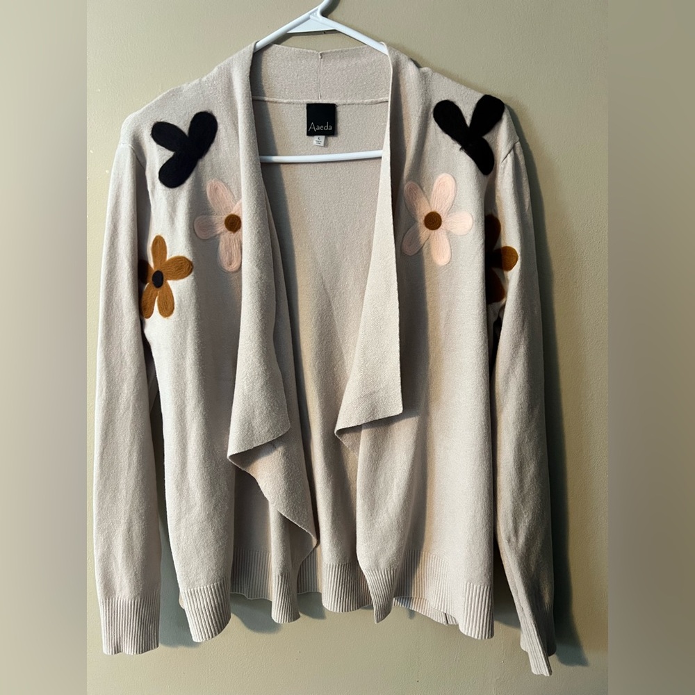 Aaeda sz L cream sweater with open drape design and felted floral embroidery.